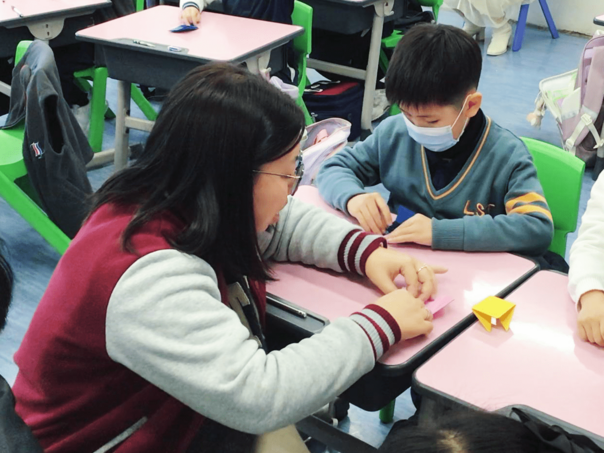 学生专注投入折纸青蛙活动，于互动与实践中体验动手学习的乐趣与成就感。