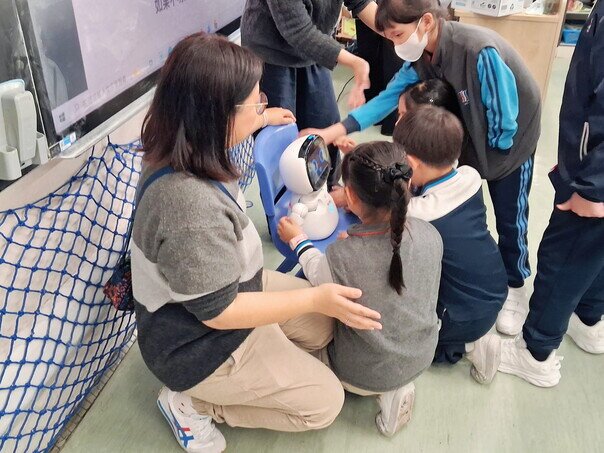 香港教育大学博士后研究员冯嘉欣博士引导学生与「爱心宝宝」机器人互动，现场气氛热烈。