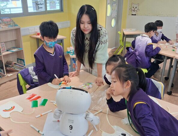 同学在工作坊中积极与「爱心宝宝」机械人互动交流。