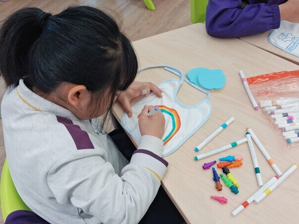 同学专心为「爱心宝宝」机械人设计可爱服饰。