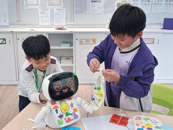 同学为「爱心宝宝」佩戴自制服饰。